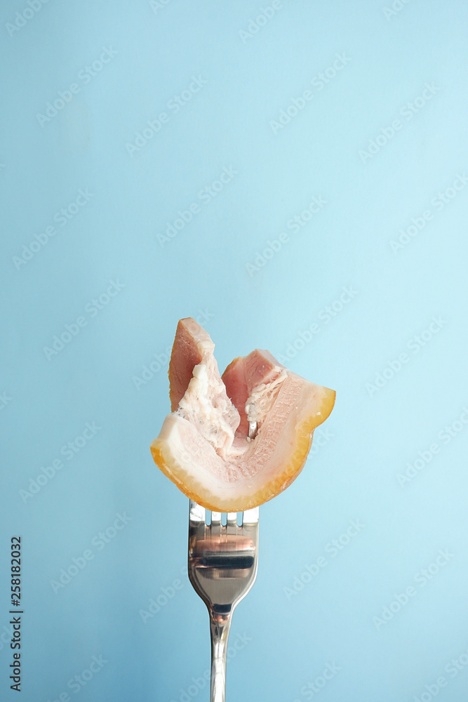 Wall mural Bacon on the fork. Blue background with empty place for text