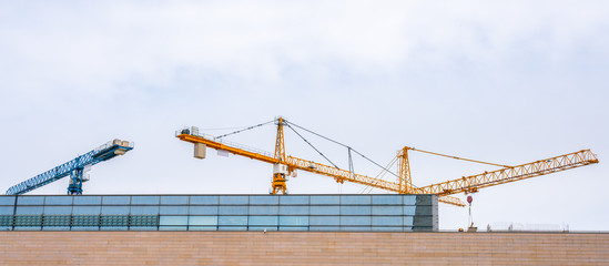 Fototapeta na wymiar Three construction cranes at a construction site.