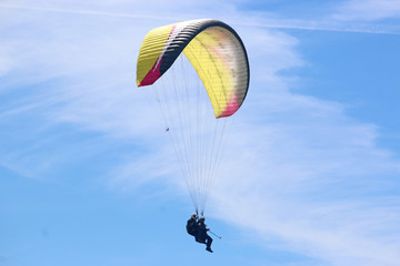 Tandem paraglider flying yellow wng