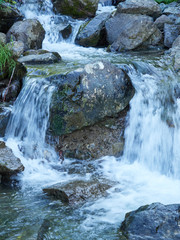 A powerful mountain stream flows down from the rocks and stones.