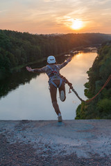 Girl jumping from the bridge. A girl with an incredible time is engaged in freestyle in bungee...