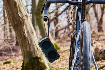 portable bluetooth speaker on a bicycle in the woods , gravel