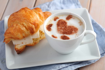 French breakfast: croissant sandwich with cheese and a cup of coffee cappuccino