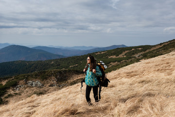 Fototapeta premium Hiking girl on a high green mountain.