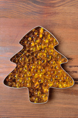 capsules with fish oil spread out in the form of a tree on a wooden background