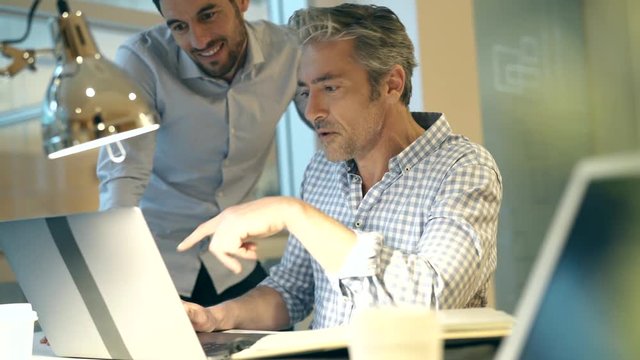 Casual businessmen discussing ideas infront of computer