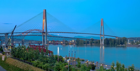 Sky Train Bridge  over the Fraser River between New Westminster and Surrey, Promenade quay at Fraser River in New Westminster city in night time.  British Columbia Canada