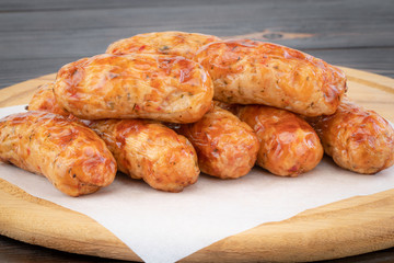 Tasty grilled sausage on the wooden background