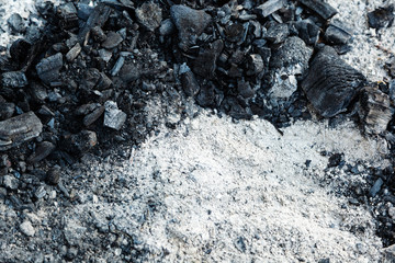 Ash and charcoal cooled after burning. Extinguished and cooled down fire made of wood. Background of coals and ash texture.