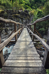 Fototapeta premium Beautiful wooden hand-made bridge in the Ecopath White River, near Kalofer, Bulgaria. Nature preservation while giving people access is the goal.