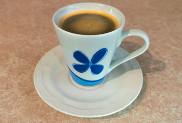 Black coffee with cream in a cup.