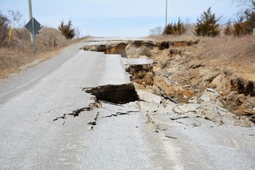 A road is destroyed by erosion caused by spring runoff.