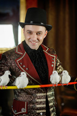magician holds on forgive pigeons. The trainer of pigeons. Magic performance with pigeons