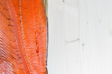 Cold smoked pink salmon on a wooden background with Place for text