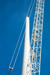 Building and assembling a construction windmill by a crane, The Netherlands. Blue sky