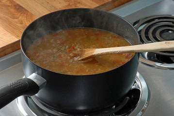Steam rising from boiling pot of chicken and sausage gumbo.
