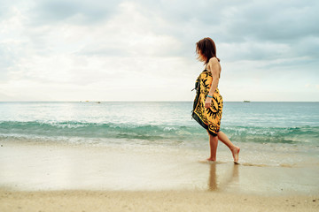 beautiful young girl in pareo walking on the sunset beach on sunlight in Philippines - Summer...