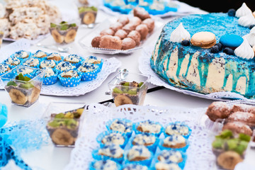 Beautiful variety of sweets on table with blue decorations