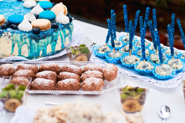 Beautiful variety of sweets on table with blue decorations