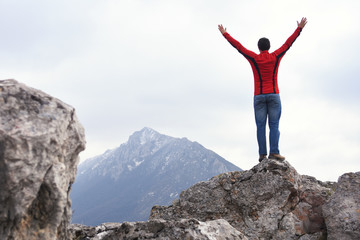 Man rise a hands on top of the mountain. Concept of freedom, man on wild nature in mountains