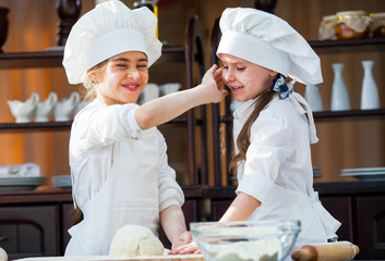 two girls make flour dough.