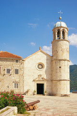 Fototapeta na wymiar Religious architecture. View of ancient Church of Our Lady of the Rocks ( Gospa od Skrpjela ) on sunny summer day. Montenegro, Bay of Kotor