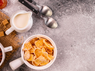 cornflakes, coffee, cottage cheese, bread, butter, eggs, jam and other ingredients for breakfast on a dark background. Top view with copy space