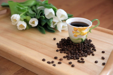 tulips and coffee on wooden board