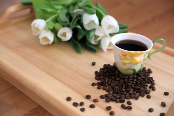 tulips and coffee on wooden board