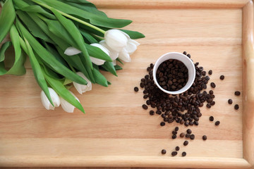 tulips and coffee on wooden board