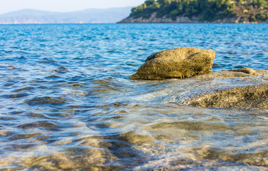 tropic Mediterranean sea vivid colorful local scenic wallpaper landscape of rocky lagoon shoreline with stone above blue water, nature pattern concept with empty copy space for text 