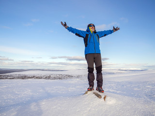 A man at the top of a snowy mountain with his hands up