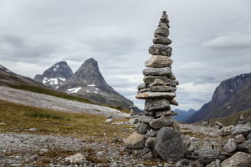 Manmade pyramide of small rocks with big mountain behind