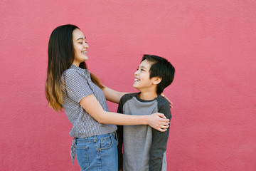 View of a brother and sister embracing and having fun on a sunny day