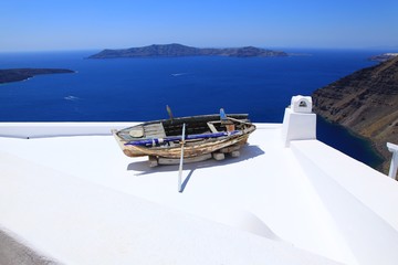 Sea view and an old boat on a roof on Santorini