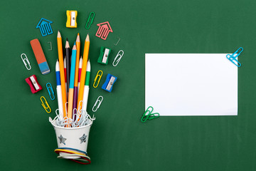Stationery Pencils paper clip pen eraser in a white bucket. Still life on green school board background. Copy space Flat lay Top view Concept Education