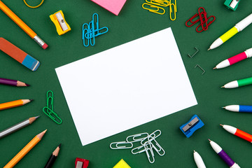 School stationery lies on a green school board forming a frame for text. near pencil and crumpled pages. Copy space Flat lay Top view Concept Education