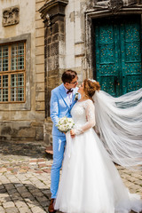 Wedding couple hugging each other. Woman with lace veil. Lady and guy outdoors