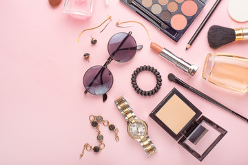 Obraz na płótnie Canvas Beauty concept in a blog. Professional female make-up accessories, watch, bracelet, lipstick, powder, on a pink background. Women's background and fashion. Instagram, women's things. Flat lay
