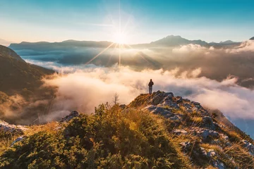 Zelfklevend Fotobehang Successful hiker enjoying at top of mountain above clouds © Novak