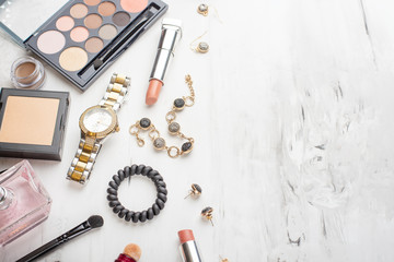 flat lay-up of female cosmetics collage frame with lipstick, brushes on a marble white background. view from above