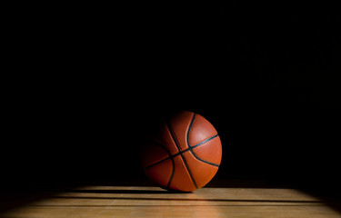 Basketball ball on the parquet with black background