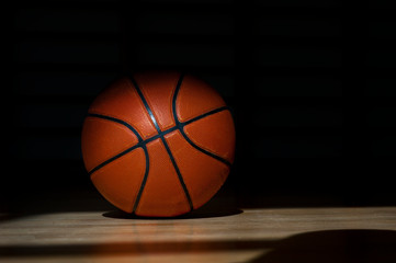 Obraz premium Basketball ball on the parquet with black background