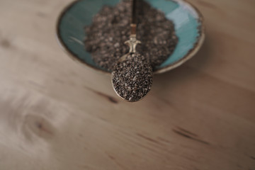 Chia seeds in a spoon on wooden background. Vegan food concept