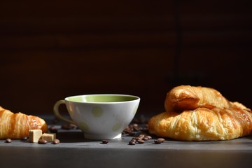 Coffee cup and fresh croissants on a black background. Coffee moon 