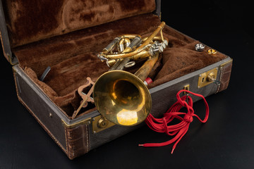 Old covered patina trumpet in a case. A historic wind musical instrument and a suitcase.