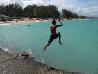 Young man jumping into the sea
