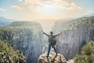 Obraz premium Young traveller enjoying a looking at sunset on Panoramic mountains view. Traveling, active lifestyle concept