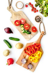 cooking with raw vegetables on white background top view