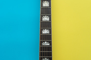 Acoustic guitar neck centered on blue and yellow background